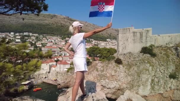 Dívka s chorvatskou vlajkou na hradbách Dubrovníku — Stock video