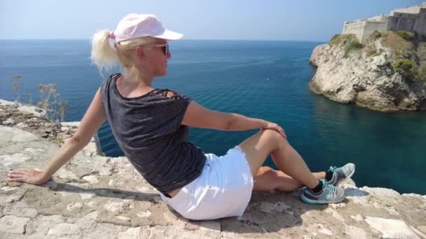Hırvatistan 'ın Dubrovnik şehrinin tepesinde oturan kadın — Stok video