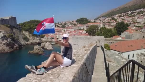 Dubrovnik 'in tepesinde Hırvat bayrağı taşıyan kadın — Stok video