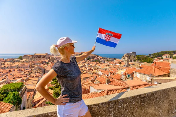 Nainen, jolla on Kroatian lippu Dubrovnikin muurilla — kuvapankkivalokuva