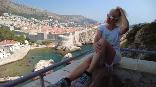 Mulher sentada no topo da cidade de Dubrovnik, na Croácia — Vídeo de Stock