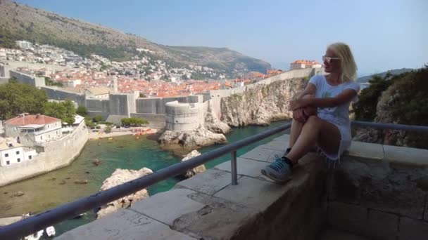 Femme assise au sommet de la ville croate de Dubrovnik — Video