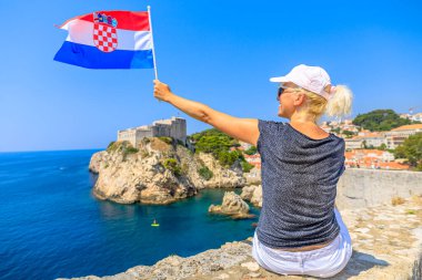Dubrovnik 'in tepesinde Hırvat bayrağı taşıyan kadın