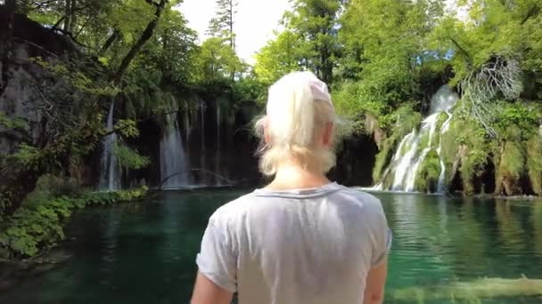 Vrouw uitziende waterval in Nationaal Park Plitvice Meren — Stockvideo