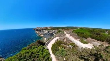 Drone view from mount Leone of the Bonifacio bay with Secret Beach and King Aragon Steps. Aerial view of the cliffs on the Bonifacio French town in Corsica island of France in Mediterranean sea.