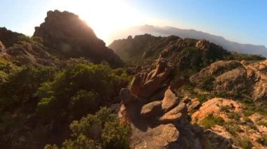 Aerial view on the road in Corsican badlands called Les Calanques in Mediterranean sea by the Porto Ota town. Aerial drone view of sunset badlands Calanques of Piana. UNESCO heritage