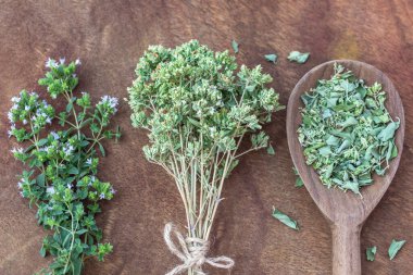 Dried marjoram and fresh twigs marjoram on a wooden background, spice, herb, organic food. Food background. Alternative medicine. Healthy eating. High quality photo clipart