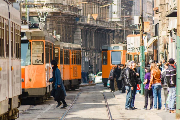Milan, İtalya; 23 Mart 2011: Şehir merkezindeki bir caddede halk ve tramvaylar.