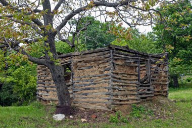 An old abandoned house made of mud and wooden beams in the forest