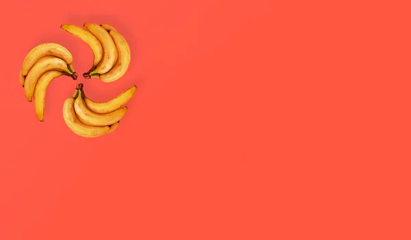 Куча Бананов Лежащих Кругу Плоская Композиция Апельсиновом Фоне Баннер Концепция — стоковое фото
