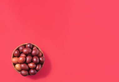 Kırmızı arka planda paskalya yumurtaları. Fotokopi alanı olan düz yatay bileşim, Paskalya Bayramı için minimum süsleme kavramı