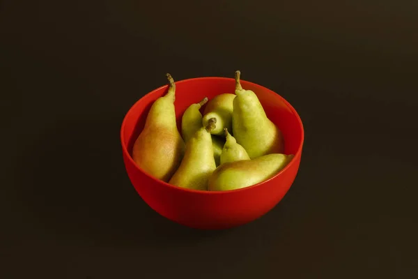 Pears in red bowl on a pastel red background. Minimal horizontal composition, heatlthy eating concept