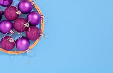 Mor Noel ağacı süsleme topları, arka planda ahşap çember şeklinde. Fotokopi alanı, Noel ve Yeni Yıl kutlamaları konseptine sahip minimum düzlük burç kompozisyonu