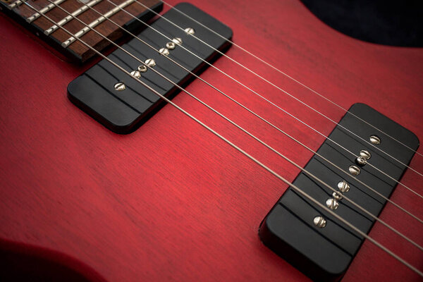 Extreme Closeup of Red Colored Guitar with Dark Bokeh Background