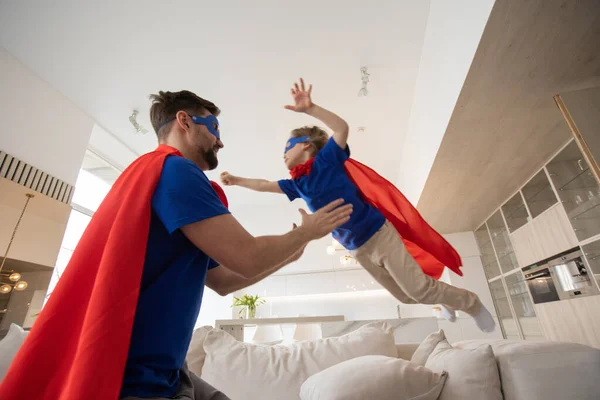 Otec Drží Syna Létat Kostýmu Superhrdiny Doma — Stock fotografie