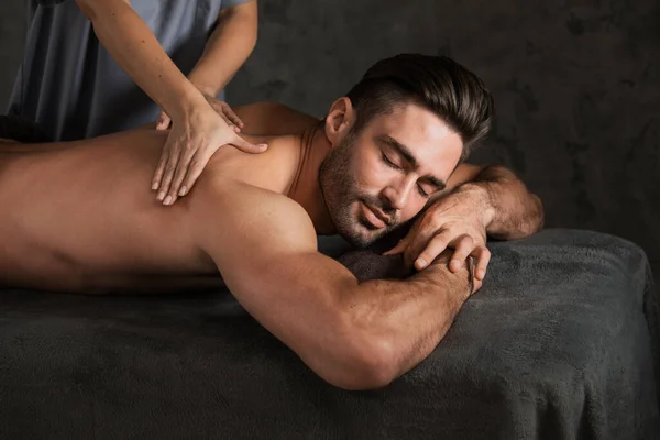 Ένας Όμορφος Άντρας Κάνει Μασάζ Στην Πλάτη Ξαπλωμένος Στο Spa — Φωτογραφία Αρχείου