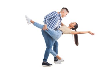 Genç adam ve kadın tango yapıyor ve beyaz arka planda yalnız gülümsüyor.