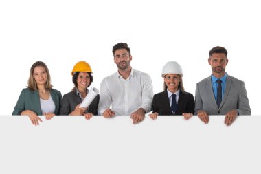 Mimarlar ve iş adamlarından oluşan bir grup inşaat işçisi beyaz arka planda izole edilmiş kopya alanı ile boş afiş sunuyorlar.