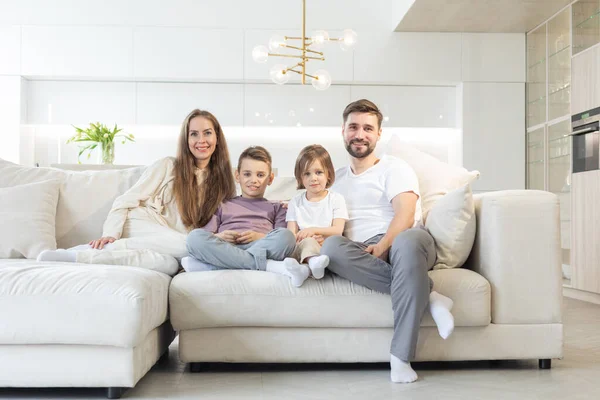 Family Parents Two Children Relaxing Sofa Home — Stok fotoğraf