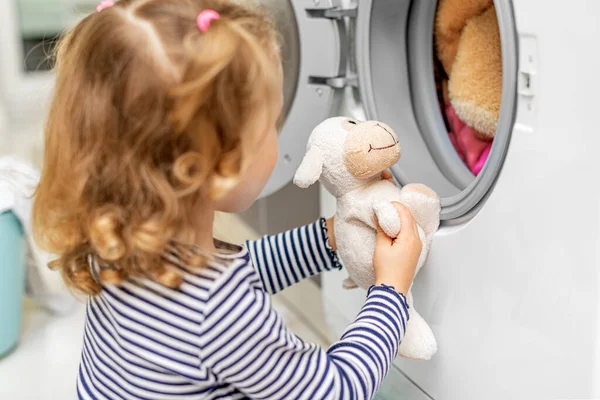 Çocuk çamaşır makinesinin nasıl yıkandığını izliyor.. — Stok fotoğraf