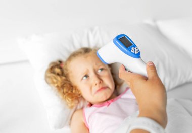 Remote thermometer for measuring body temperature. Sick child.