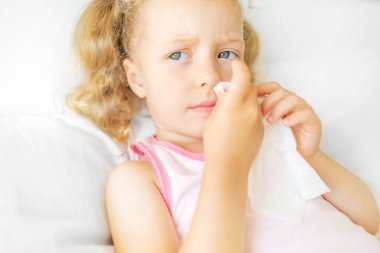 Runny nose in a child. He wipes his own nose.
