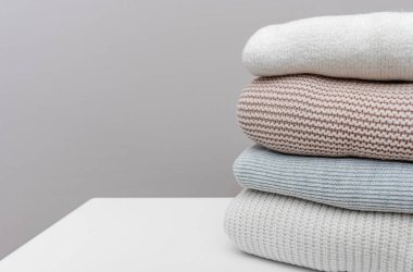 Sıcak kış kazakları komodinin üzerinde. Kış için hazırlanıyor.