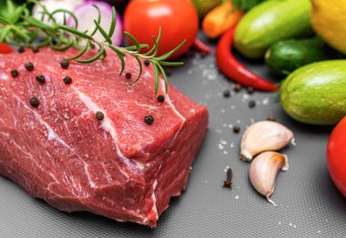 Kesme tahtasındaki çiğ et, sebze ve baharatla birlikte..