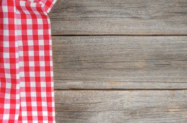 Ahşap bir arka planda kareli masa örtüsü. Metnin için bir yer var..