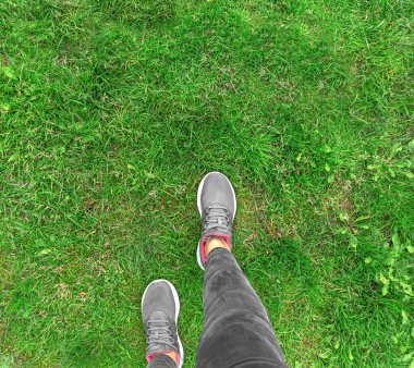 Spor ayakkabılı ayaklar çimenlerde yürür. Metin için boşluk var.