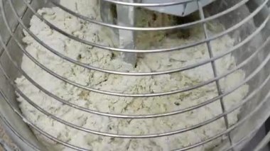 Makine hamuru yoğurur ve sarı sıvı dökülür.