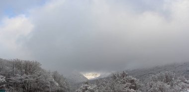 Tepenin yamacında buz ve kar var.