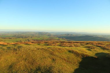 Burada kış güneşinin altında güneşlenen tepeler ve vadiler