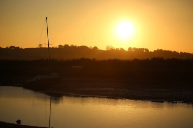 Sonbahar boyunca İngiltere 'nin Norfolk kentinde Blakeney dışında gelgit bataklıklarının üzerinde gün batımı 