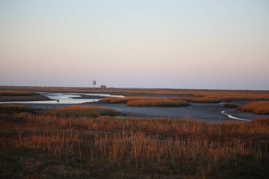 Sonbahar boyunca İngiltere 'nin Norfolk kentinde Blakeney dışında gelgit bataklıklarının üzerinde gün batımı 