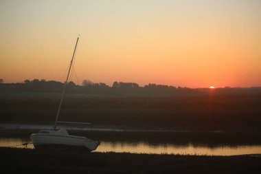 Sonbahar boyunca İngiltere 'nin Norfolk kentinde Blakeney dışında gelgit bataklıklarının üzerinde gün batımı 