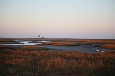 Sonbahar boyunca İngiltere 'nin Norfolk kentinde Blakeney dışında gelgit bataklıklarının üzerinde gün batımı 