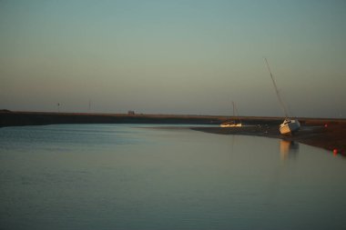 Sonbahar boyunca İngiltere 'nin Norfolk kentinde Blakeney dışında gelgit bataklıklarının üzerinde gün batımı 