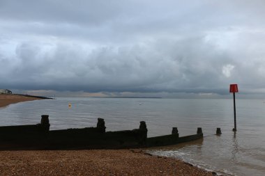 Yazın sonlarına doğru Whitstable, Kent, İngiltere sahillerinde gezinirken su tarafından yapılan kumların manzarasını ve şablonlarını ve çarpan dalgaları görürüz.
