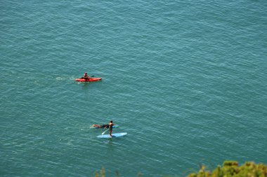 Kuzey Devon kıyısındaki mavi İngiliz denizlerinde kürek çekmek.