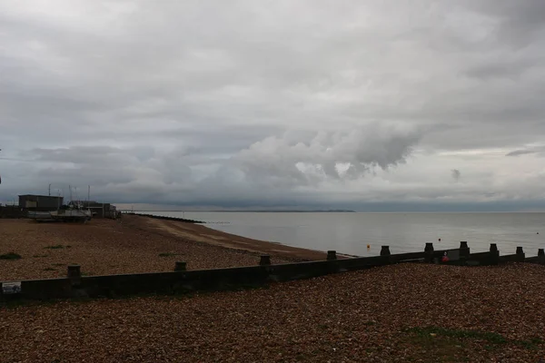 Yazın sonlarına doğru Whitstable, Kent, İngiltere sahillerinde gezinirken su tarafından yapılan kumların manzarasını ve şablonlarını ve çarpan dalgaları görürüz.
