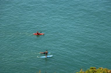 Kuzey Devon kıyısındaki mavi İngiliz denizlerinde kürek çekmek.