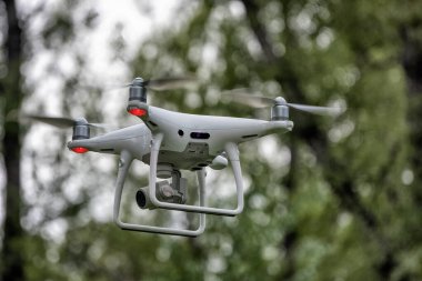 Yerden kalkan beyaz bir dron kuadkopteri. Yumuşak odaklanma. Hareket bulanıklığı.