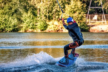 Yaz günü can yeleğiyle gölde uyanan bir adam. Yumuşak odaklanma. Eylem bulanıklığı. 