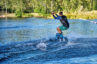 Yaz günü can yeleğiyle gölde uyanan bir adam. Yumuşak odaklanma. Eylem bulanıklığı. 