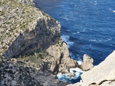 Cap Formentor, Mallorca, İspanya 'nın önündeki kayalar ve dalgalı deniz manzarası
