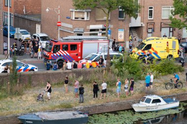 Lahey, NETHERLANDS - 20 Temmuz 2022: 112 Ambulans ve İtfaiye Motoru Lahey 'deki evin yakınındaki kalabalıkta.
