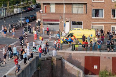 Lahey, NETHERLANDS - 20 Temmuz 2022: 112 Ambulans ve İtfaiye Motoru Lahey 'deki evin yakınındaki kalabalıkta.