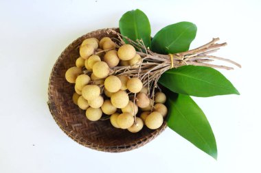 Üst manzara Dimocarpus Longan, sepetteki yeşil ve uzun yaprak beyaz arka planda izole. Taze Longan Thai meyvesi.