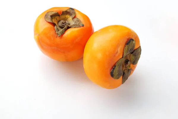 白を基調とした2枚の熟した柿 — ストック写真